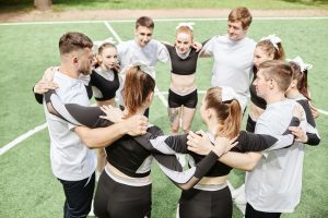 Athletes read books - High school team forming a circle in unity