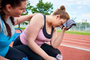 tired and frustrated female athlete getting support from her female coach