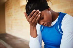 professional athlete encountering a challenge, holding her head