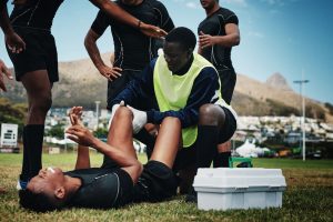 How Long Does It Take to Become an Athletic Trainer? - rugby player receiving first aid treatment during an injury