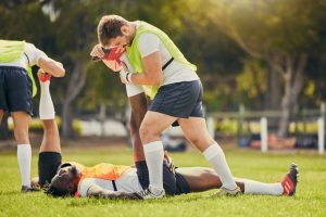 How Long Does It Take to Become an Athletic Trainer? - sports trainer stretching the leg of an athlete