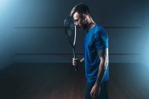 Feel Lazy If You Miss Racket Sport in the Morning - Man feeling lazy holding racket