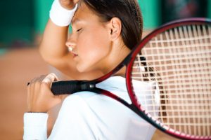 Feel Lazy If You Miss Racket Sport in the Morning - woman holding her head feeling lazy