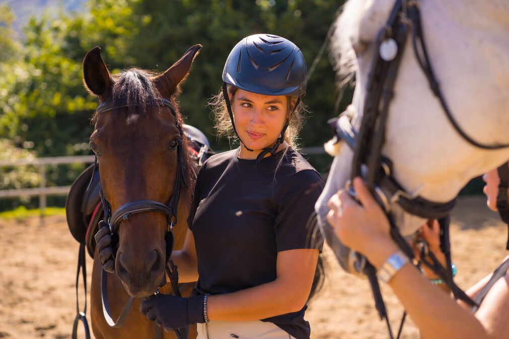 Workouts for Horseback Riders - female rider standing beside a horse