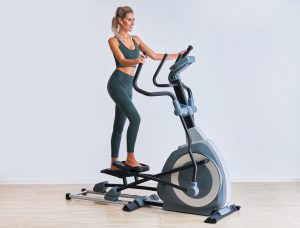 exercise machines - slim white lady on an elliptical machine